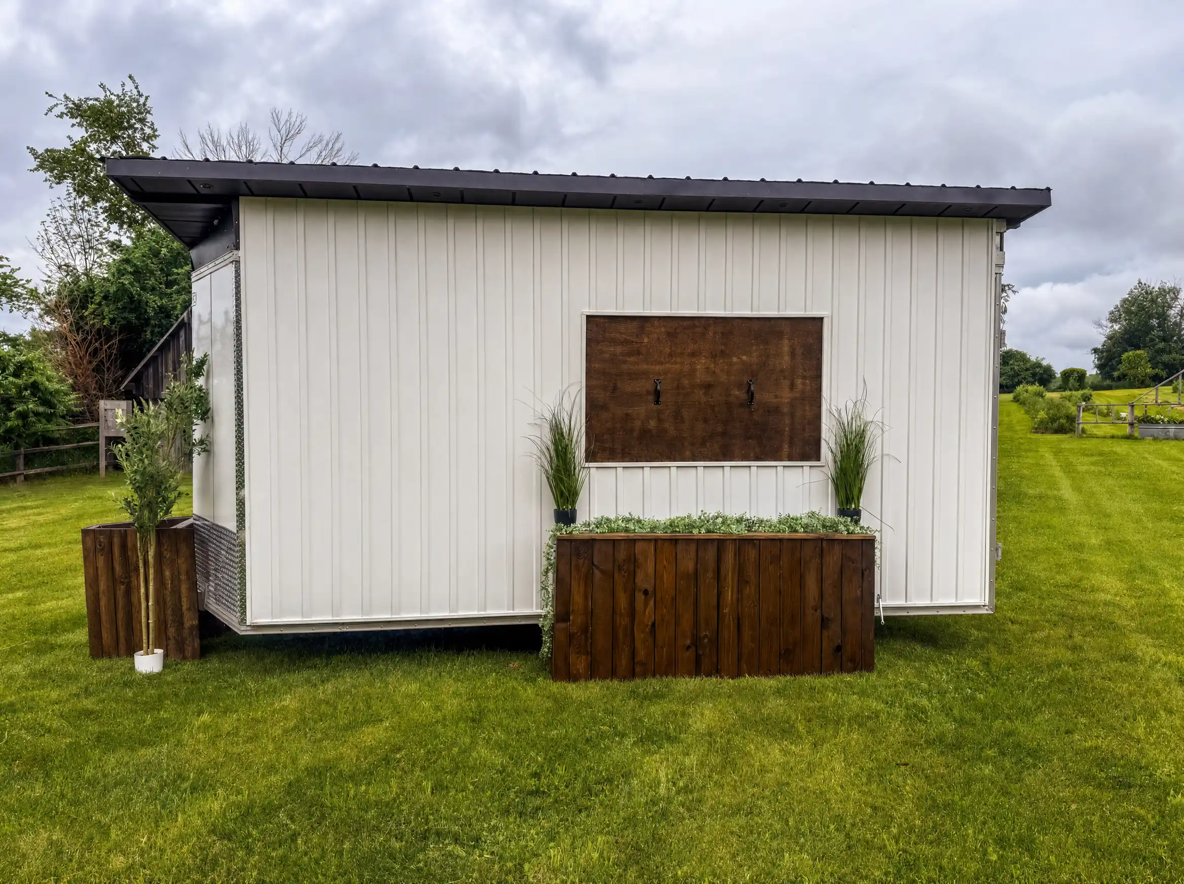The Loaded Wagon mobile bar set up outdoors on a grass lawn on an overcast day.